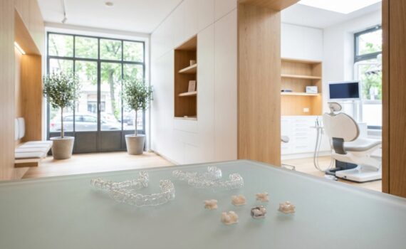 Moderne kieferorthopädische Praxis mit transparenten Alignern und Brackets auf Glasoberfläche